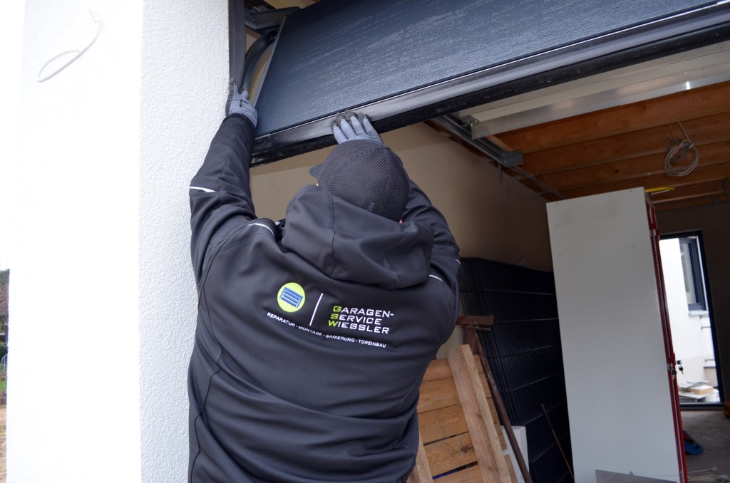 Martin Wiessler ist am Reparieren eines Garagentors, Problem des Garagentoantriebs